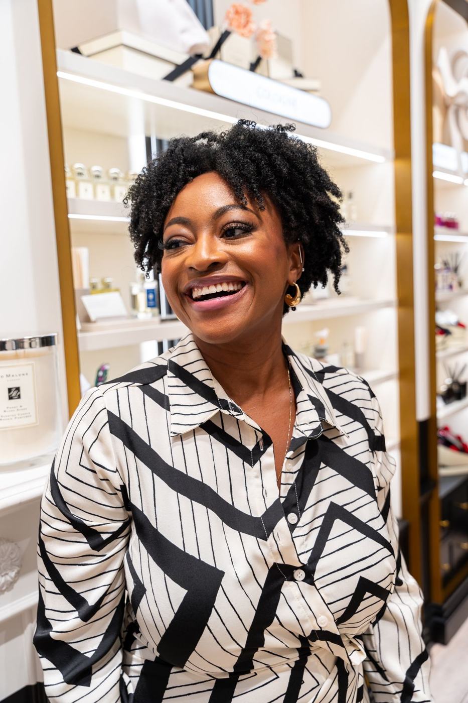 Dammy Oshodi smiling inside a Jo Malone London store